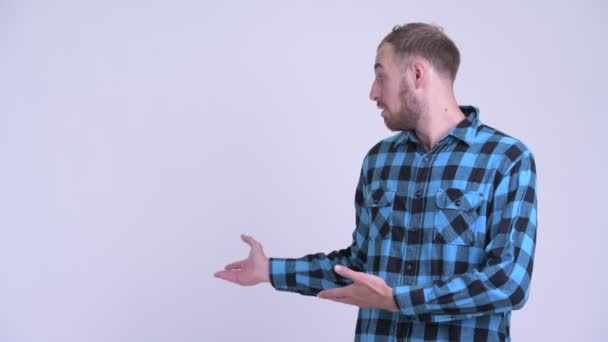 Verdrietig bebaarde hipster man die aan de achterkant toont en duimen naar beneden geeft — Stockvideo