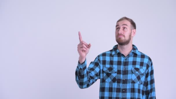Verdrietig bebaarde hipster man die naar boven wijst en duimen naar beneden geeft — Stockvideo