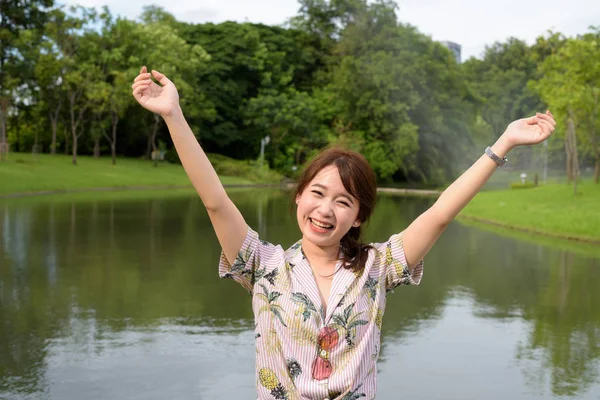 Young beautiful Asian tourist woman relaxing at the park — Stock Photo, Image