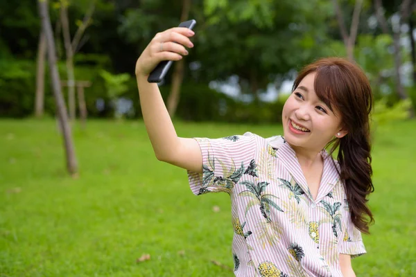 Jeune belle femme touristique asiatique se détendre au parc — Photo