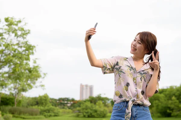 Jeune belle femme touristique asiatique se détendre au parc — Photo
