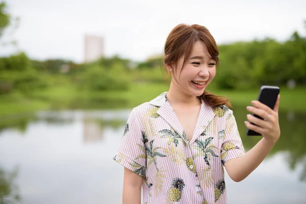 Jeune belle femme touristique asiatique se détendre au parc — Photo