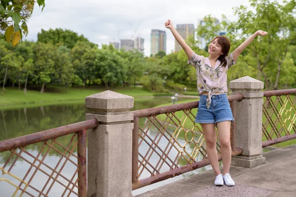 Giovane bella asiatica donna turistica rilassante al parco — Foto Stock