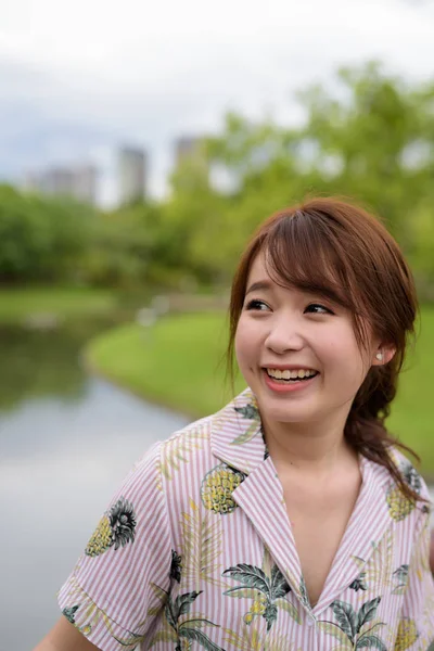 Young beautiful Asian tourist woman relaxing at the park — Stock Photo, Image