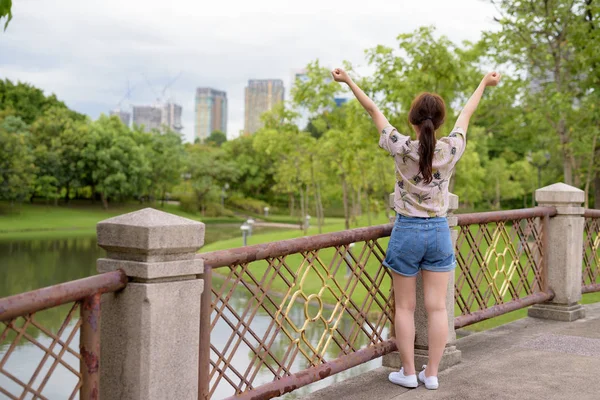 Young beautiful Asian tourist woman relaxing at the park — Stock Photo, Image