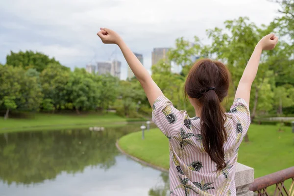 Young beautiful Asian tourist woman relaxing at the park — Stock Photo, Image