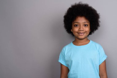 Studio shot of young cute African girl against gray background