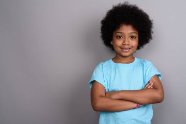 Studio shot of young cute African girl against gray background