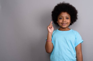 Studio shot of young cute African girl against gray background