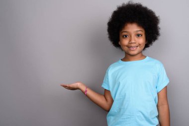 Studio shot of young cute African girl against gray background