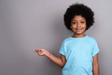 Studio shot of young cute African girl against gray background