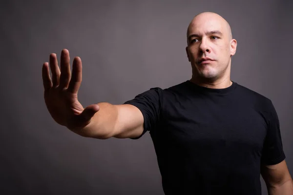 Portrait of handsome bald man against gray background — Stock Photo, Image