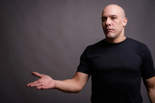 Portrait of handsome bald man against gray background — Stock Photo, Image