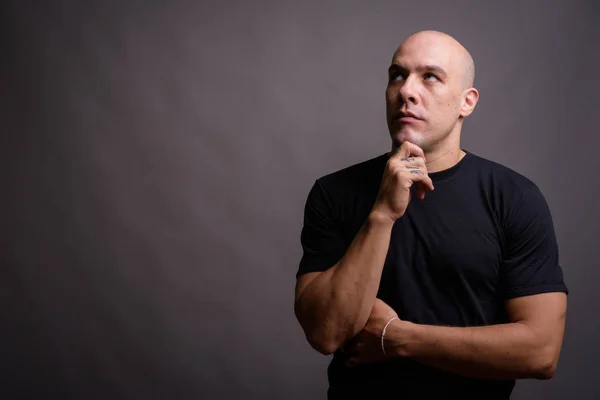 Portrait of handsome bald man against gray background — Stock Photo, Image