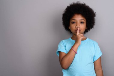 Studio shot of young cute African girl against gray background