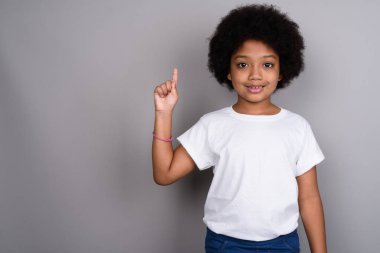 Studio shot of young cute African girl against gray background