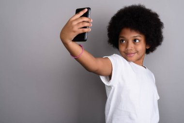 Studio shot of young cute African girl against gray background