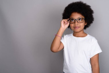 Studio shot of young cute African girl against gray background