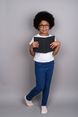 Studio shot of young cute African girl against gray background
