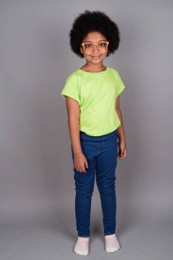 Studio shot of young cute African girl against gray background