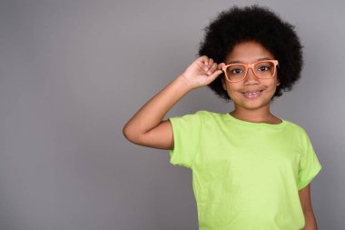 Studio shot of young cute African girl against gray background