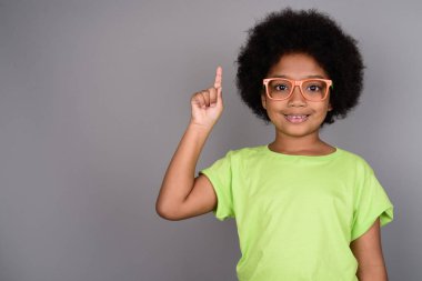 Studio shot of young cute African girl against gray background