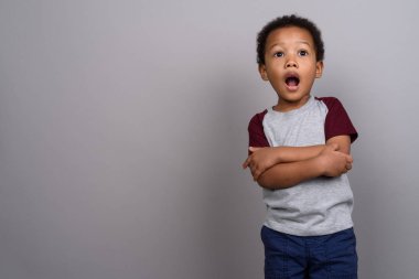 Studio shot of young cute African boy against gray background