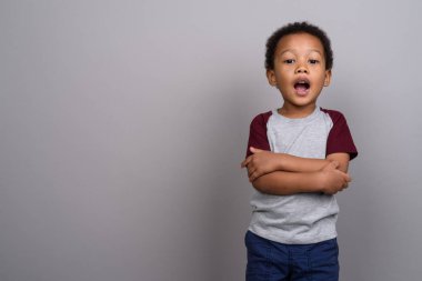 Studio shot of young cute African boy against gray background