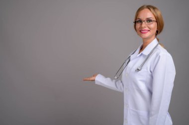 Sarışın, sırtı gri genç, güzel bir kadın doktor.