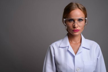 Sarı saçlı, koruyucu giyen genç ve güzel bir kadın doktor. 