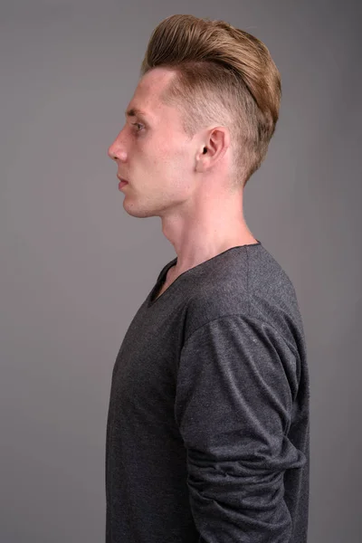 Studioaufnahme Eines Jungen Mannes Mit Blonden Haaren Vor Grauem Hintergrund — Stockfoto