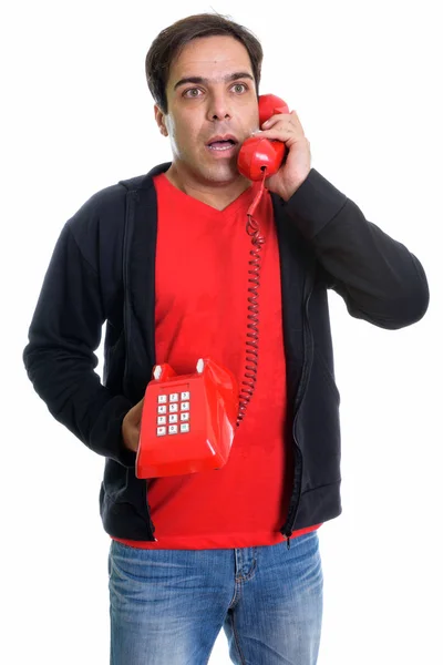 Thoughtful Young Persian Man Standing Talking Old Telephone While Looking — 图库照片