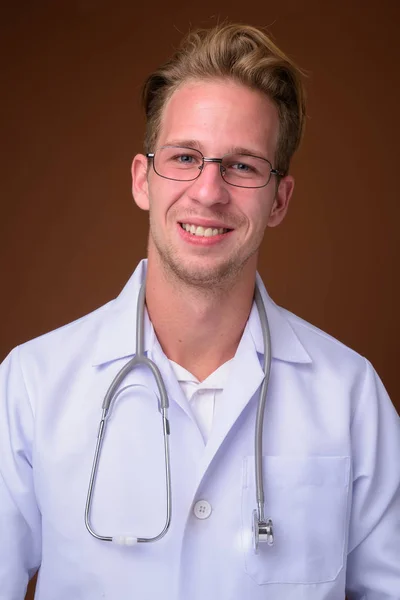 Estúdio Tiro Jovem Bonito Homem Médico Contra Fundo Marrom — Fotografia de Stock