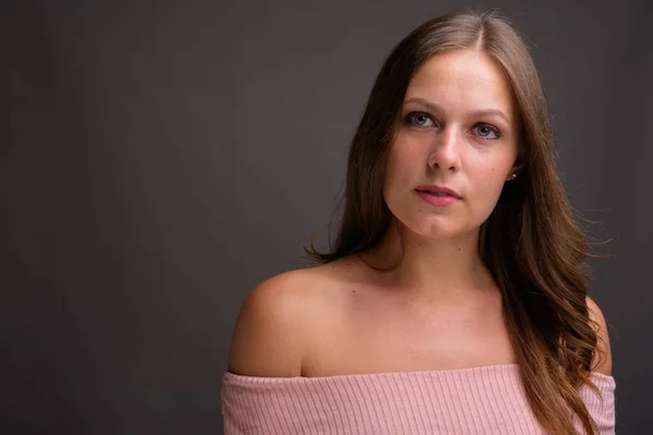 stock image Studio shot of young beautiful woman wearing pink off-shoulder top against gray background