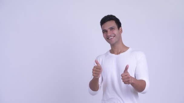 Счастливый молодой индиец, указывая вверх и показывая большие пальцы вверх — стоковое видео