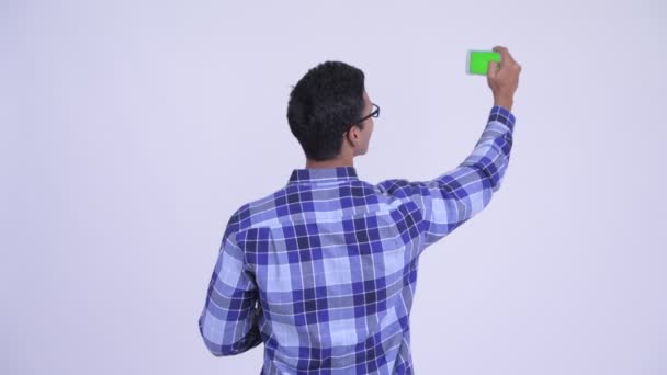 Widok z tyłu młody indyjski hipster człowiek robi zdjęcie z telefonu — Wideo stockowe