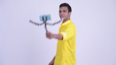 Mutlu genç Hintli işadamı telefonla konuşuyor.