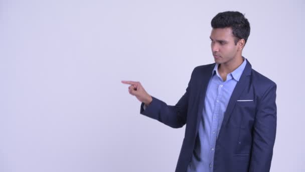 Szczęśliwy młody indyjski biznesmen dotyka czegoś i wygląda na zaskoczonego — Wideo stockowe