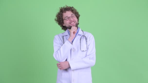 Feliz jovem barbudo homem médico pensando e olhando para cima — Vídeo de Stock