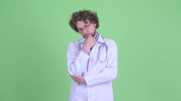 Stressed young bearded man doctor thinking and looking down — Stock Video