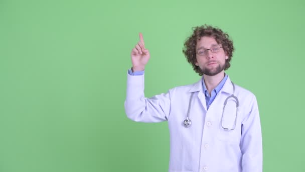 Stresli genç sakallı adam doktor işaret ve başparmak aşağı vererek — Stok video