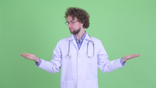 Šťastný mladý vousatý doktor co porovnává něco — Stock video