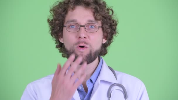 Visage de jeune homme barbu heureux médecin regardant surpris — Video