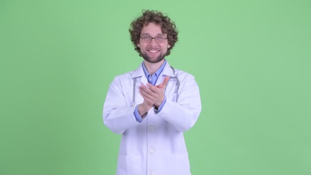 Щасливий молодий бородатий чоловік лікар плескає руками — стокове відео