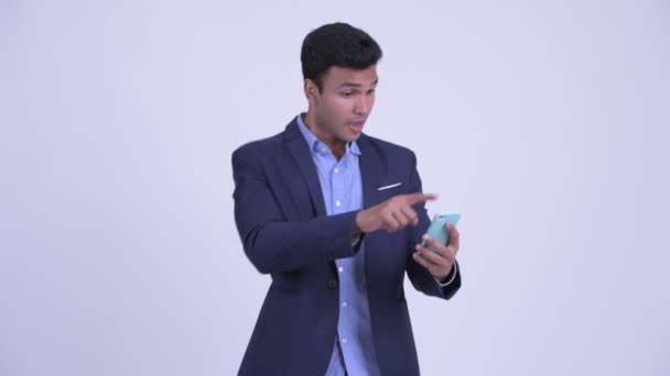 Szczęśliwy młody indyjski biznesmen za pomocą telefonu i uzyskanie dobrych wiadomości — Wideo stockowe