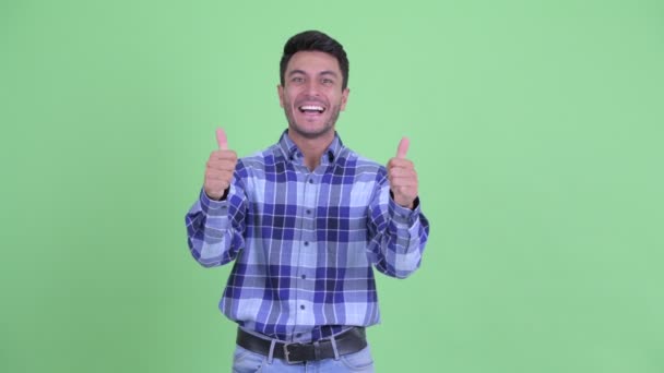 Feliz joven hispano dando pulgares hacia arriba y mirando emocionado — Vídeos de Stock