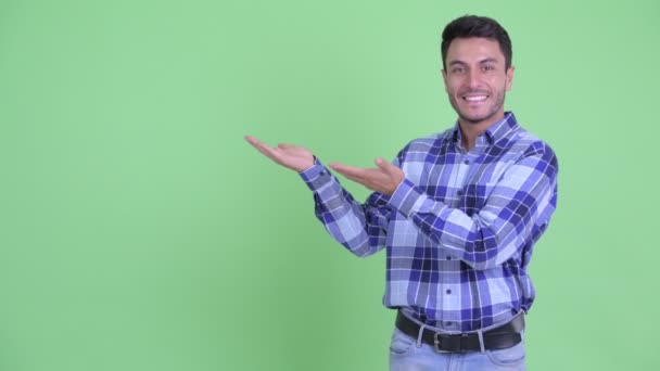 Jovem feliz bonito hispânico homem mostrando algo — Vídeo de Stock