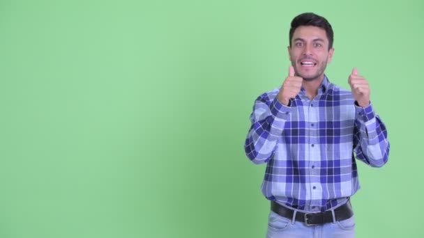 Gelukkig jonge knappe Hispanic man presenteert iets — Stockvideo
