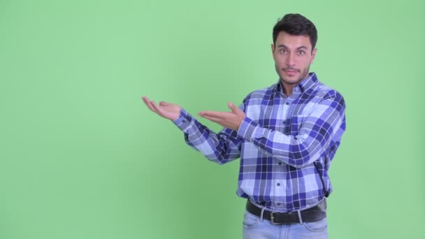 Stressed young Hispanic man showing something and giving thumbs down — Stock Video