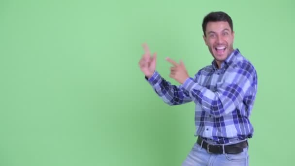 Heureux jeune homme hispanique dansant tout en montrant quelque chose — Video